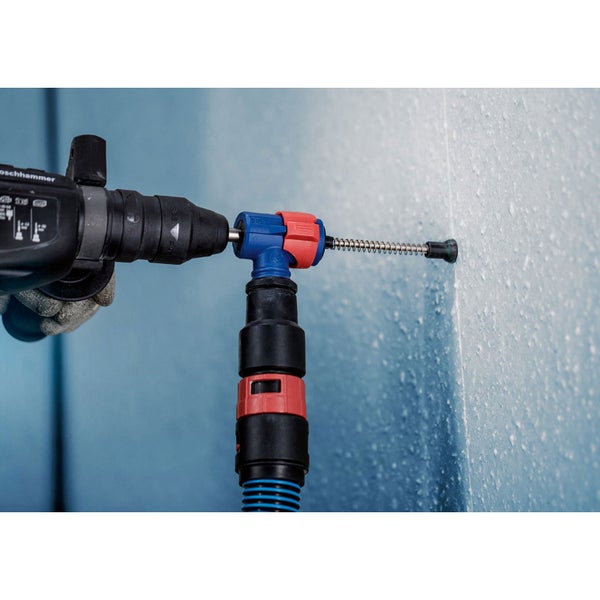 Bohrmaschine mit Staubabsaugung beim Bohren in eine Wand
