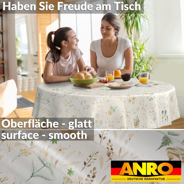 Runde Tischdecke mit Blumenmuster und glatter Oberfläche in einem hellen Esszimmer. Nahaufnahme des Materials. ANRO DEUTSCHE MANUFAKTUR Logo.