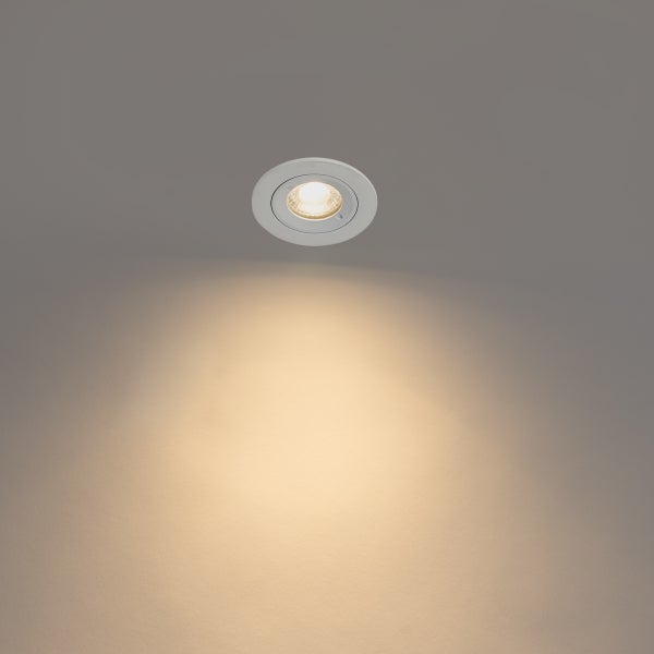 Runder LED-Einbaustrahler, eingeschaltet mit warmweißem Lichtkegel.