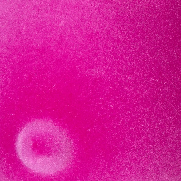 Nahaufnahme einer magenta farbenen Textiloberfläche