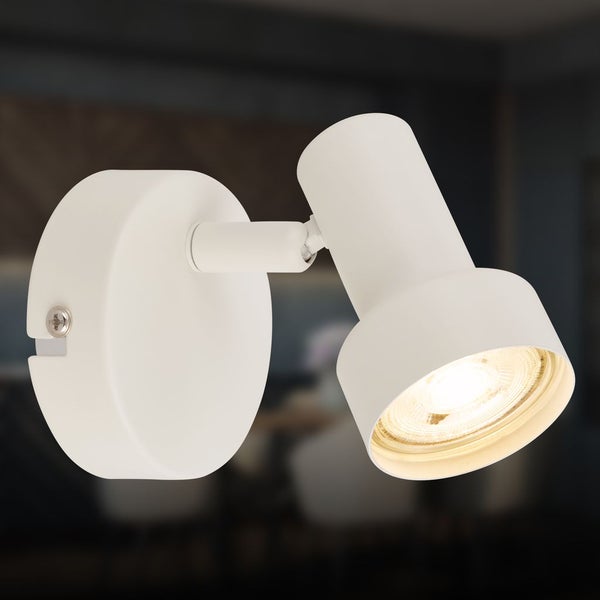 Weißer, verstellbarer Wandspot aus Metall mit rundem Sockel und zylindrischem Kopf, der warmes Licht ausstrahlt.