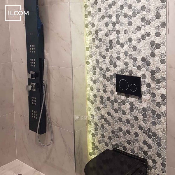 Badezimmer mit Duschpaneel, hexagonalen Wandfliesen und Hänge-WC