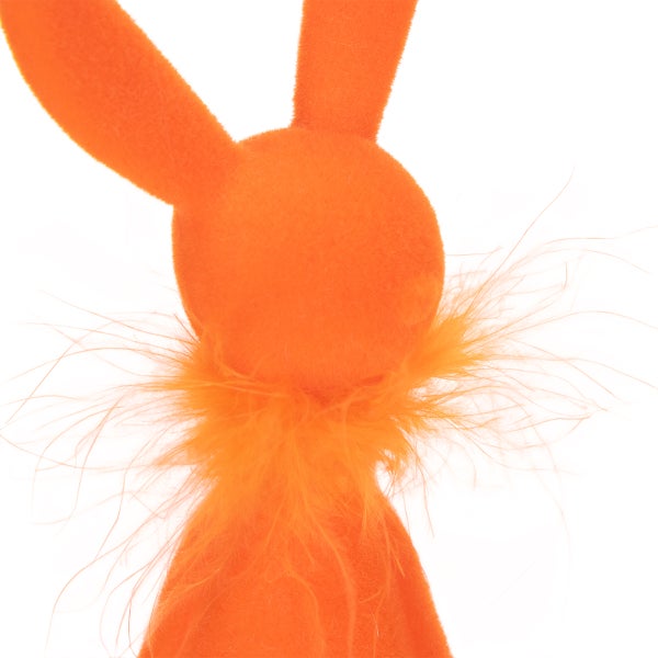 Orangefarbene Hasenfigur mit Federn am Hals als Dekoration