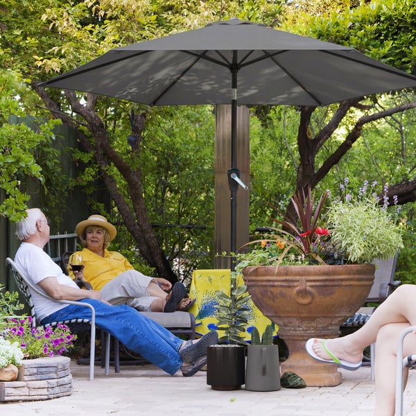 Neigbarer Sonnenschirm mit einem Durchmesser von 2,7 Meter über einer Sitzgruppe aus Polyrattan auf einer sonnigen Terrasse.