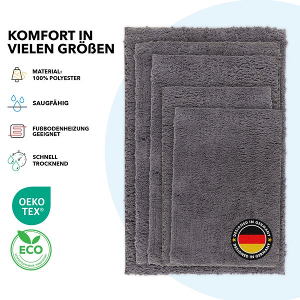 Mehrere graue Badteppiche aus Polyester in verschiedenen Größen mit den Aufdrucken Material 100 Prozent Polyester, Saugfähig, Fußbodenheizung geeignet, Schnell trocknend, Oeko Tex Standard 100 Siegel, Eco Schadstofffreier Kunststoff Siegel und Designed in Germany Siegel