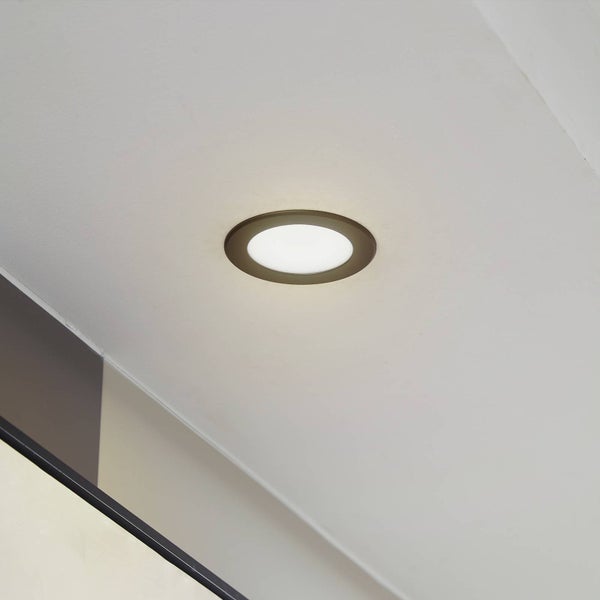 Eingeschaltete runde LED-Einbauleuchte an der Decke.