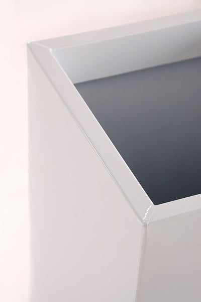 Detailansicht der Ecke eines weißen Metall-Pflanzgefäßes.