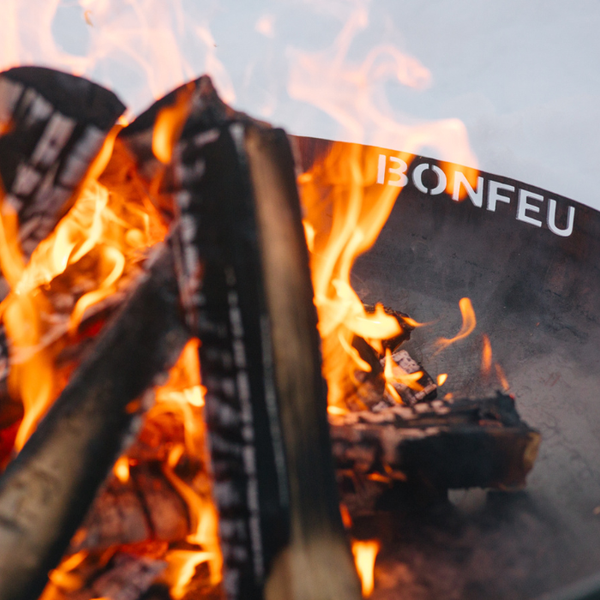 Brennendes Holz in einer Feuerschale mit Bonfeu Logo.