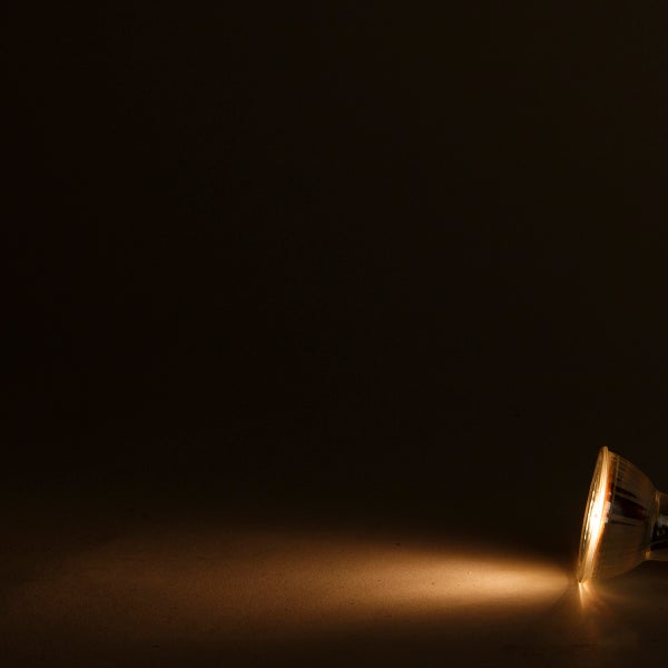 Eingeschaltetes Reflektor-Leuchtmittel mit warmweißem Lichtkegel.