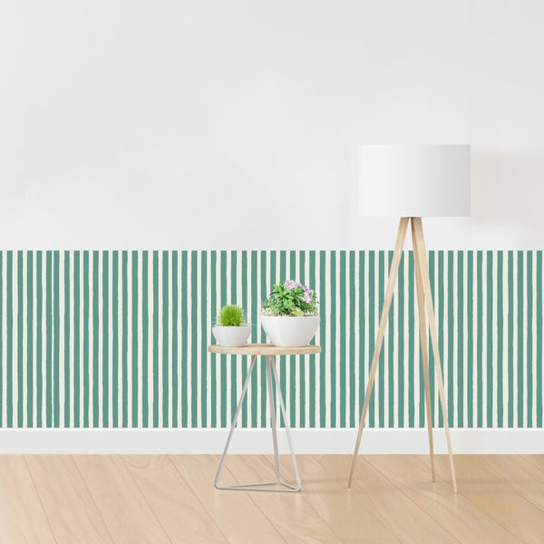 Raumszene mit Stehlampe, Beistelltisch mit Pflanzen und Tapete mit Streifenmuster
