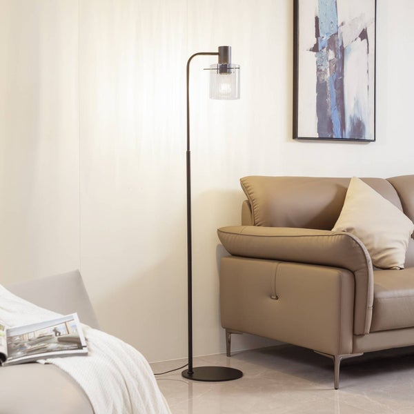 Stehleuchte mit Glasschirm neben Couch und Sessel