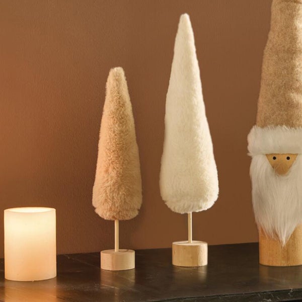 Dekorative Weihnachtsfiguren in Tannenbaumform aus Plüschmaterial mit Holzständer auf einem Tisch neben einer LED Kerze.