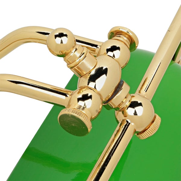 Detailansicht einer Schreibtischlampe mit grüner Lampenabdeckung und goldfarbenem Gestell