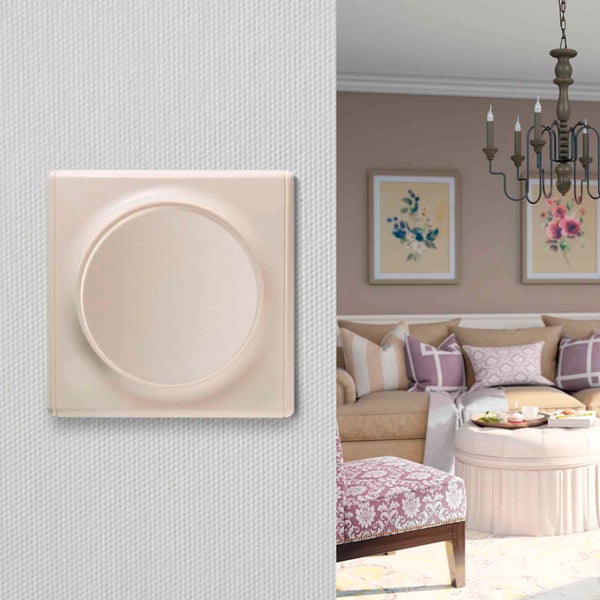 Eleganter runder Drehdimmer für die Unterputzmontage an einer hellen Wand, daneben ein Ausschnitt eines gemütlich eingerichteten Wohnzimmers.