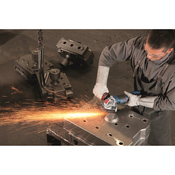 Handwerker bei der Metallbearbeitung mit einem Bosch Winkelschleifer in einer Werkstattumgebung mit Funkenflug und schweren Metallteilen.