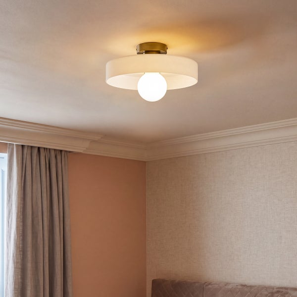 Moderne Deckenleuchte mit rundem Stoffschirm und zentraler Glühbirne an einer metallenen Deckenhalterung in einem Wohnraum.