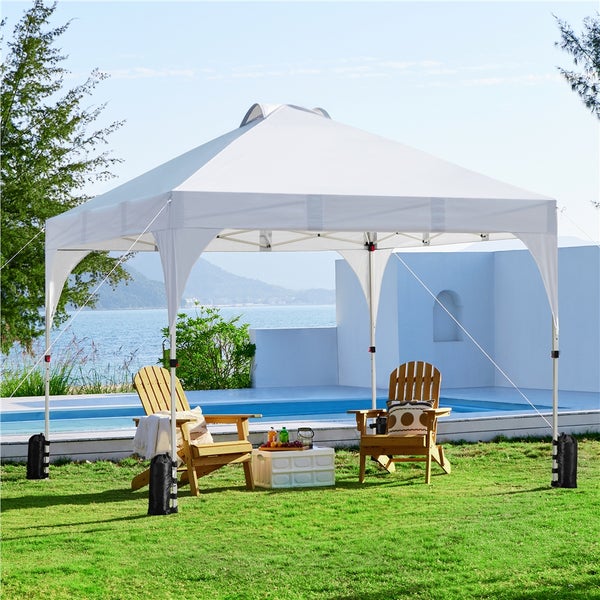 Weißes Gartenzelt mit Holzstühlen auf einer Rasenfläche