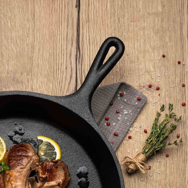 Gusseisenpfanne mit Lamm, Zitrone und Thymian auf Holztisch