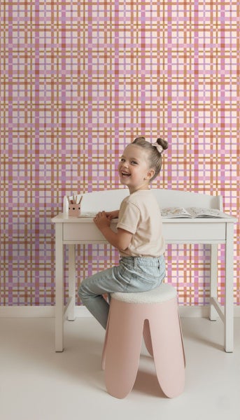 Vliestapete mit Karomuster in einem hellen Kinderzimmer mit Schreibtisch und einem lächelnden Kind.