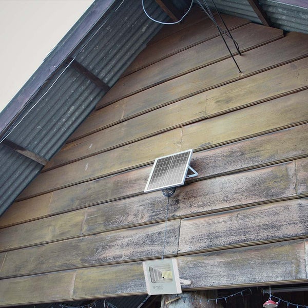 Solarpanel mit LED-Strahler an einer Holzwand montiert