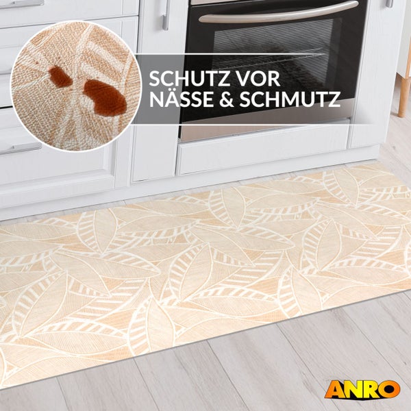 Küchenläufer mit Blattmuster vor Küchenzeile. Nahaufnahme zeigt Schutz vor Nässe und Schmutz. ANRO Logo.