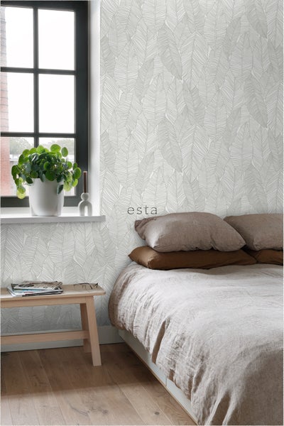 Schlafzimmer mit Bett und Wandtapete mit Blattmuster von Esta Home