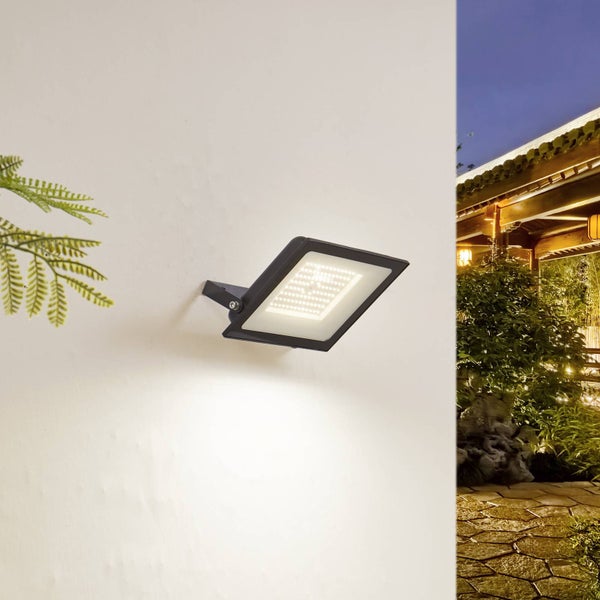 LED-Fluter für den Außenbereich, montiert an einer hellen Wand, beleuchtet einen nächtlichen Garten.