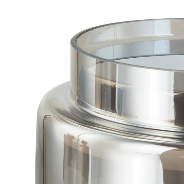 Detailaufnahme vom Rand einer Glasvase mit reflektierender, metallischer Oberfläche.