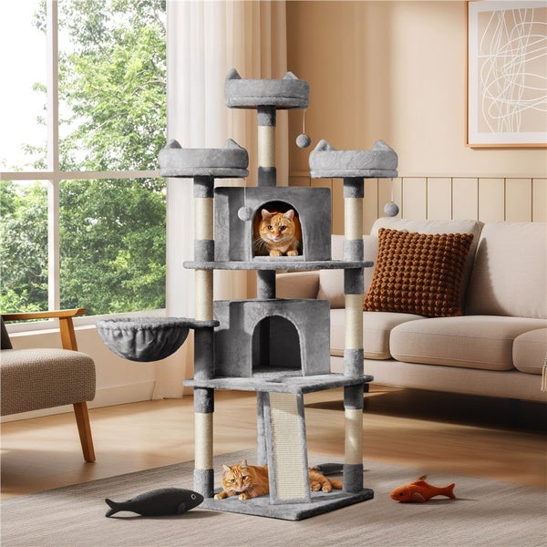 Mehrstöckiger Katzenbaum mit Kratzbaumstämmen, Plattformen, Höhlen und Spielzeug in einem Wohnzimmer mit zwei Katzen