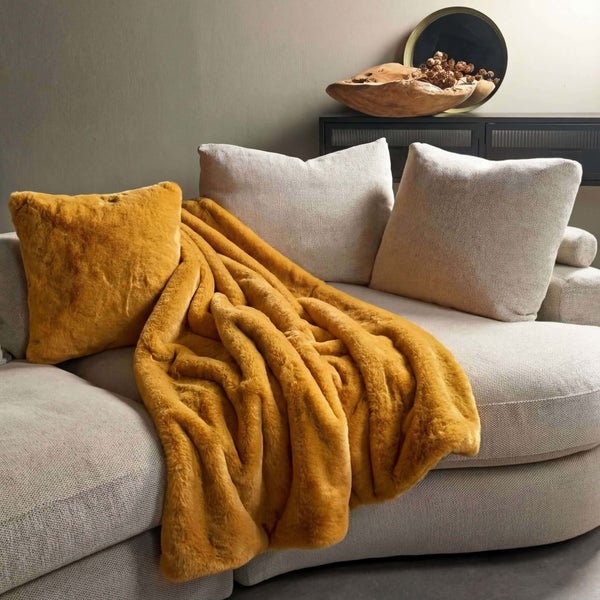 Dekoratives Wohnzimmer mit Couch, Kissen und goldgelber Decke