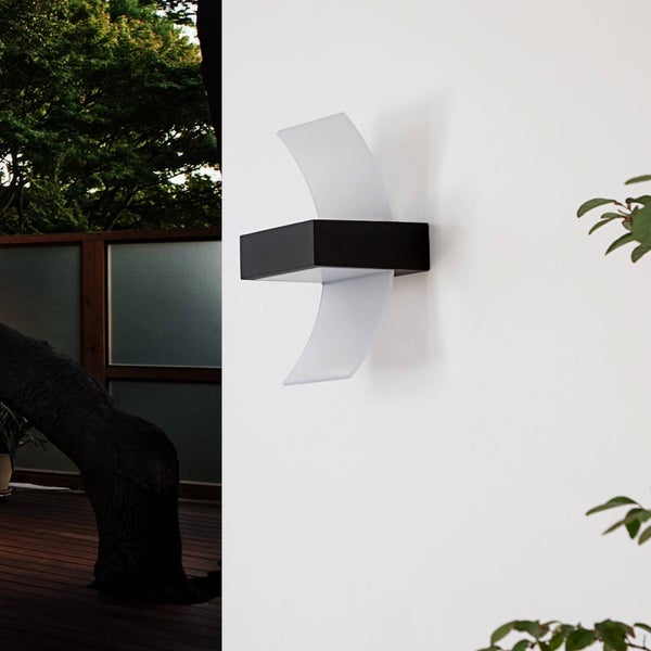 Moderne Außenwandleuchte mit schwarzem Gehäuse und zwei geschwungenen weißen Diffusoren an einer Hauswand.