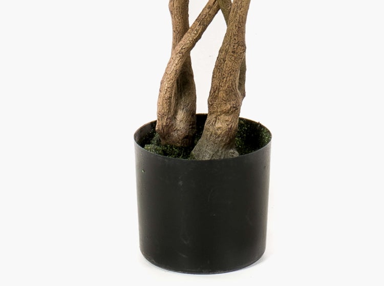 Künstliches Gras in einem schwarzen, quadratischen Übertopf.