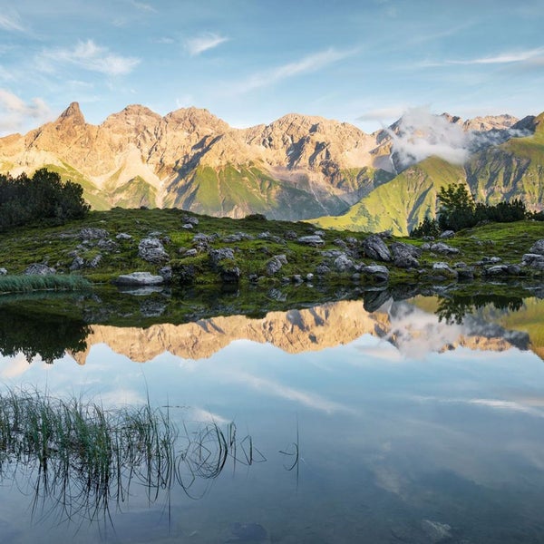 Berglandschaft mit See und Spiegelung der Berge im Wasser