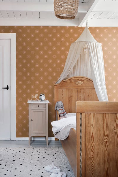 Kinderzimmer mit Bett, Nachttisch, Teppich und gemusterter Tapete