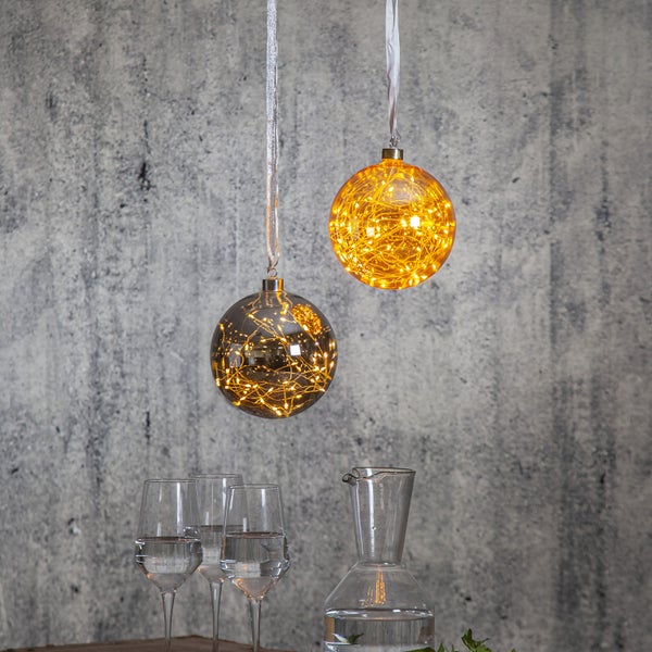 Dekorative Szene mit zwei gläsernen Kugelleuchten und Getränkegefäßen