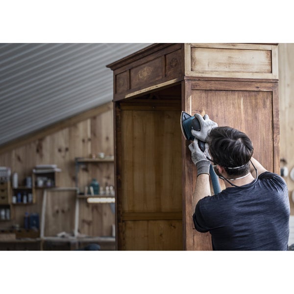 Mann arbeitet mit einem Multifunktionswerkzeug an einem Küchenschrank