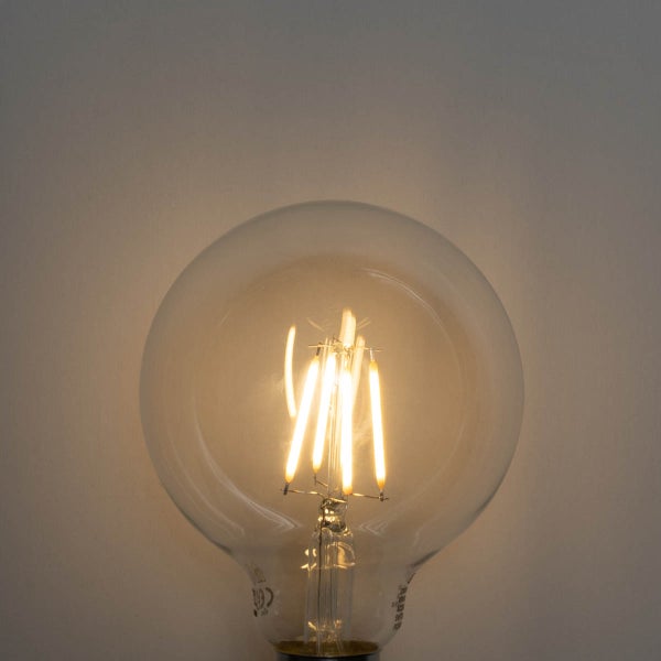 Leuchtendes LED-Filament-Leuchtmittel in Globusform aus klarem Glas.