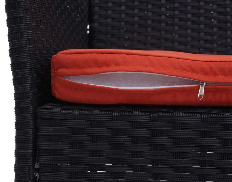 Detailansicht eines Gartenstuhls aus Polyrattan mit orangefarbenem Sitzkissen und geöffnetem Reißverschluss für den abnehmbaren Bezug.