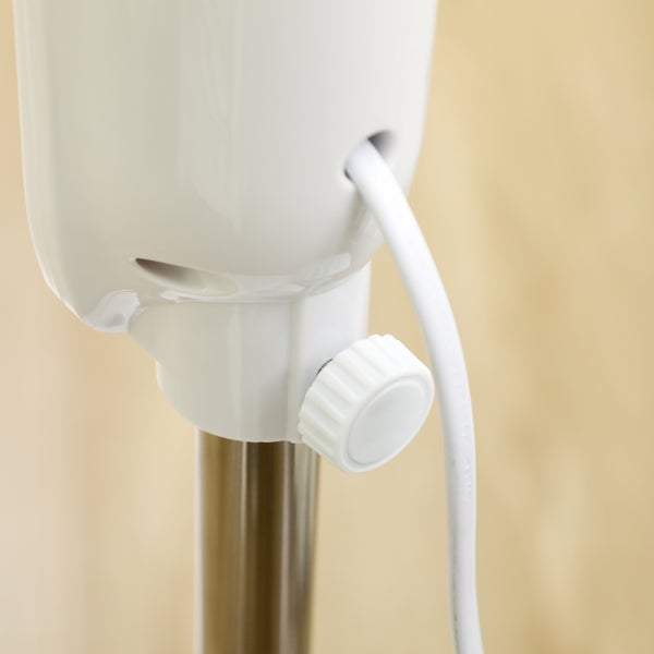 Nahaufnahme eines Standventilators mit Verstellknopf, Stromkabel und Metallstange.