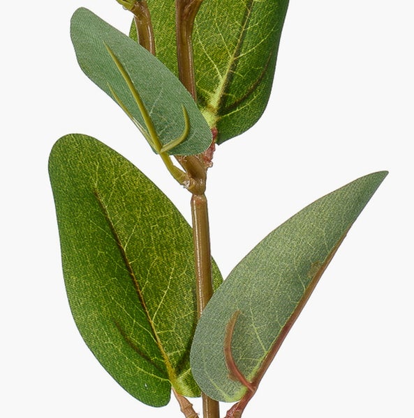 Künstlicher Zweig mit grünen Blättern in der Nahaufnahme.