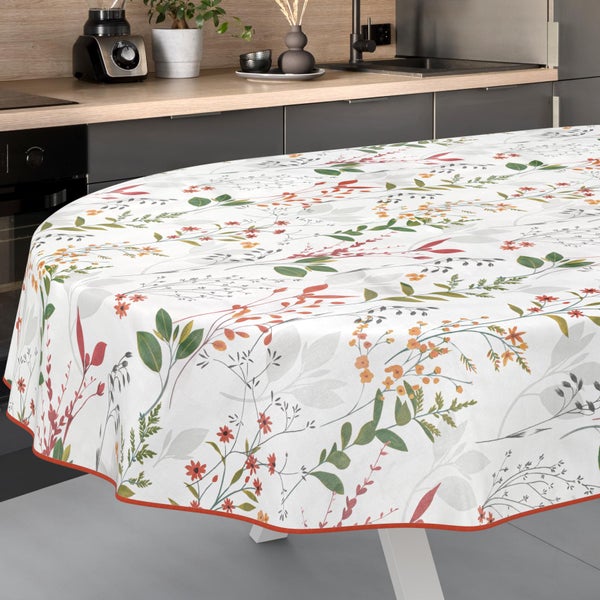 Runde Tischdecke mit floralem Muster aus Blättern und kleinen Blüten in einer modernen Küche.