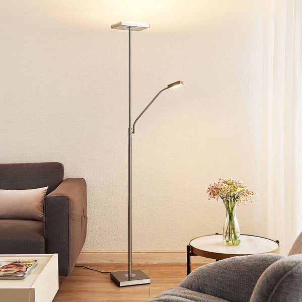 Moderne LED-Stehleuchte aus Metall mit Deckenfluter und flexiblem Lesearm in einem hellen Wohnzimmer neben einem Sofa.