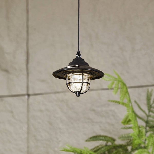 Schwarze Außenpendelleuchte im Industriestil mit Metallschirm und Glaszylinder in einem schützenden Drahtkorb.