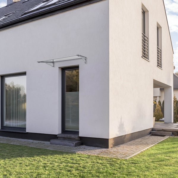 Moderne Haustürüberdachung montiert über einem Hauseingang an einer hellen Fassade eines modernen Einfamilienhauses.