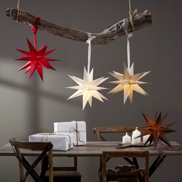 Dekorativer Tisch mit Sternenlichtern, Geschenken und Kerzen für eine festliche Atmosphäre