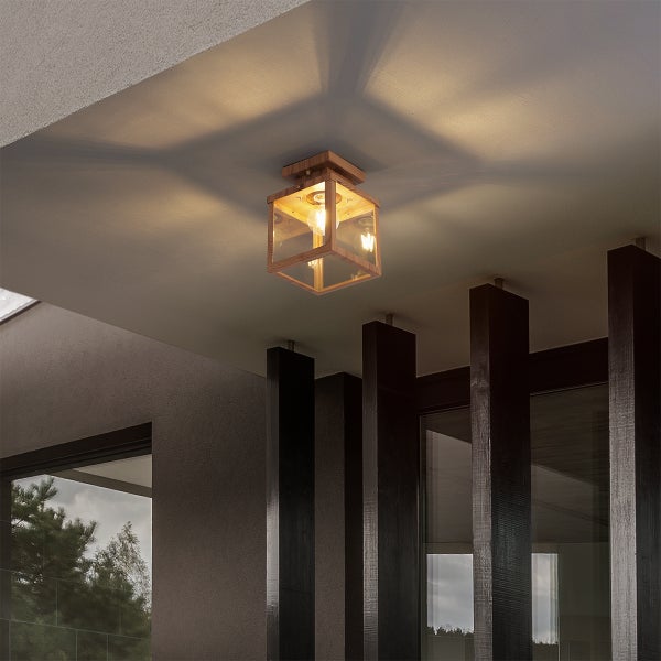 Quadratische Außen-Deckenleuchte aus Holz und Glas an einem modernen Vordach mit dunklen Holzpfeilern und warmem Licht an der Decke.