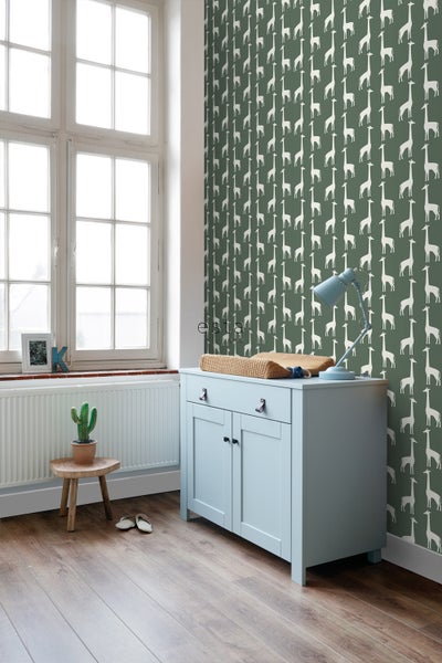 Kinderzimmer mit Giraffen-Tapete, Wickelkommode und Holzboden.