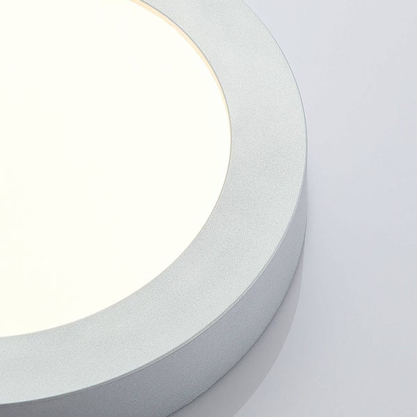Detailaufnahme einer runden LED Aufbauleuchte mit silberfarbenem Rahmen und weißer Leuchtfläche.