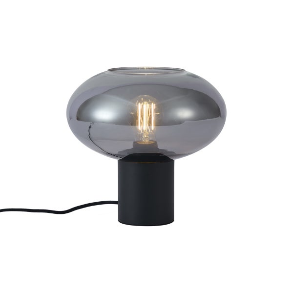Tischleuchte mit schwarzem zylindrischem Fuß und rauchgrauem ovalem Glasschirm sowie dekorativem Leuchtmittel.