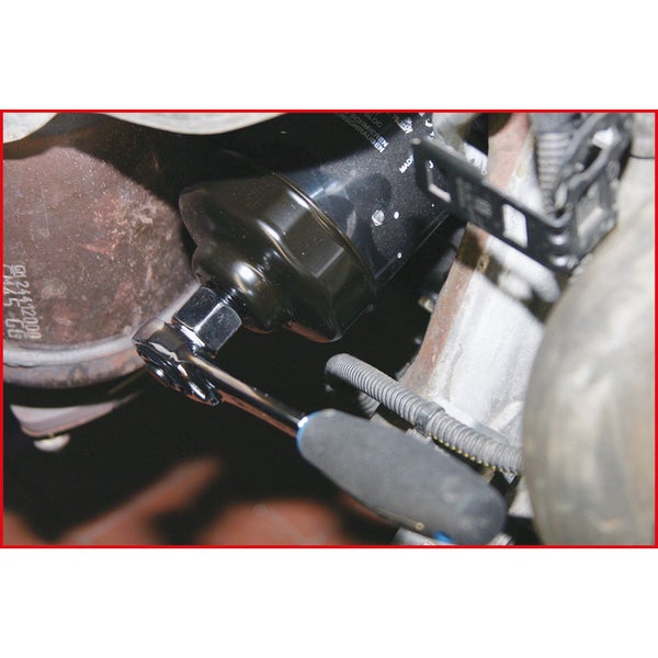 Ein Ölfilter wird mit einem Schraubenschlüssel an einem Motor befestigt.